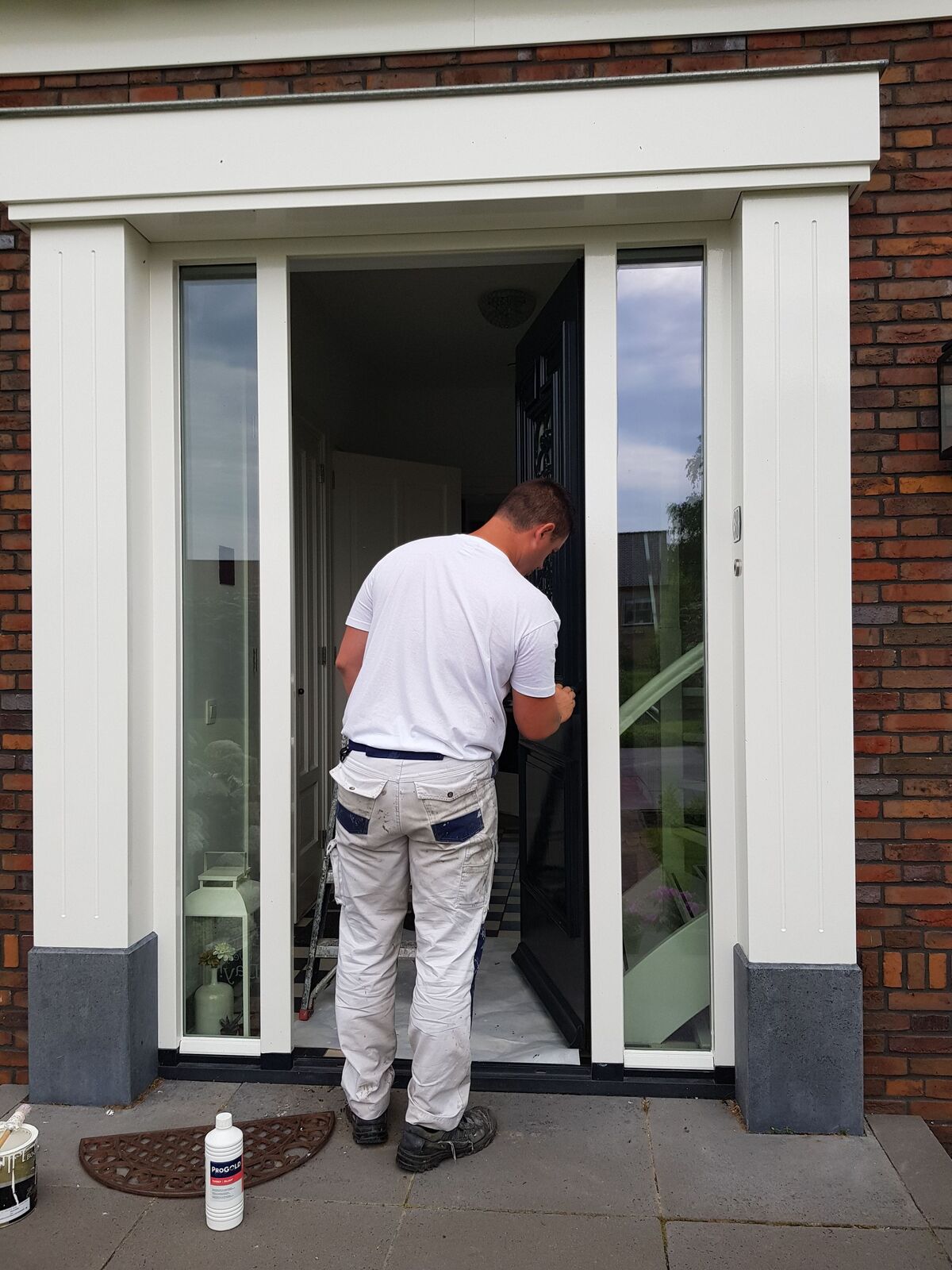 Schilder van F & E Schildersbedrijf werkt aan het houtwerk van een woning