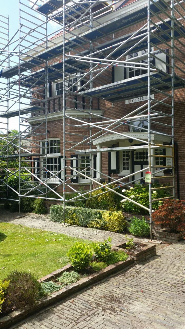 Woning volledig in de steigers tijdens schilderwerk