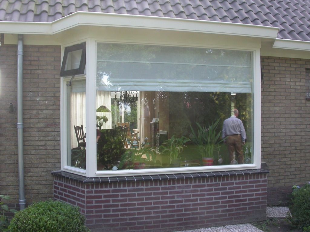 Geschilderde erker met wit kozijn aan een woning