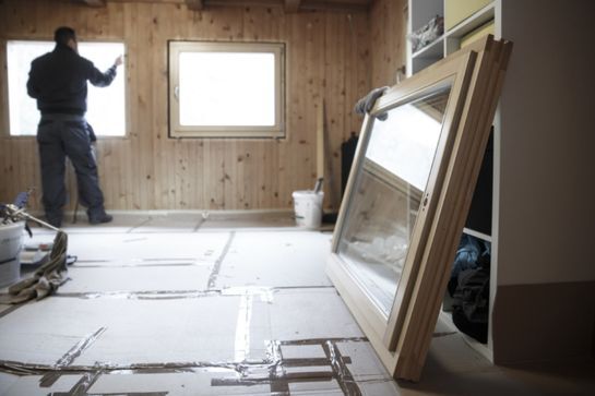 Glaszetter met nieuwe ruiten klaar voor plaatsing in een woning